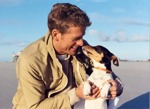Man mit Hund am Strand