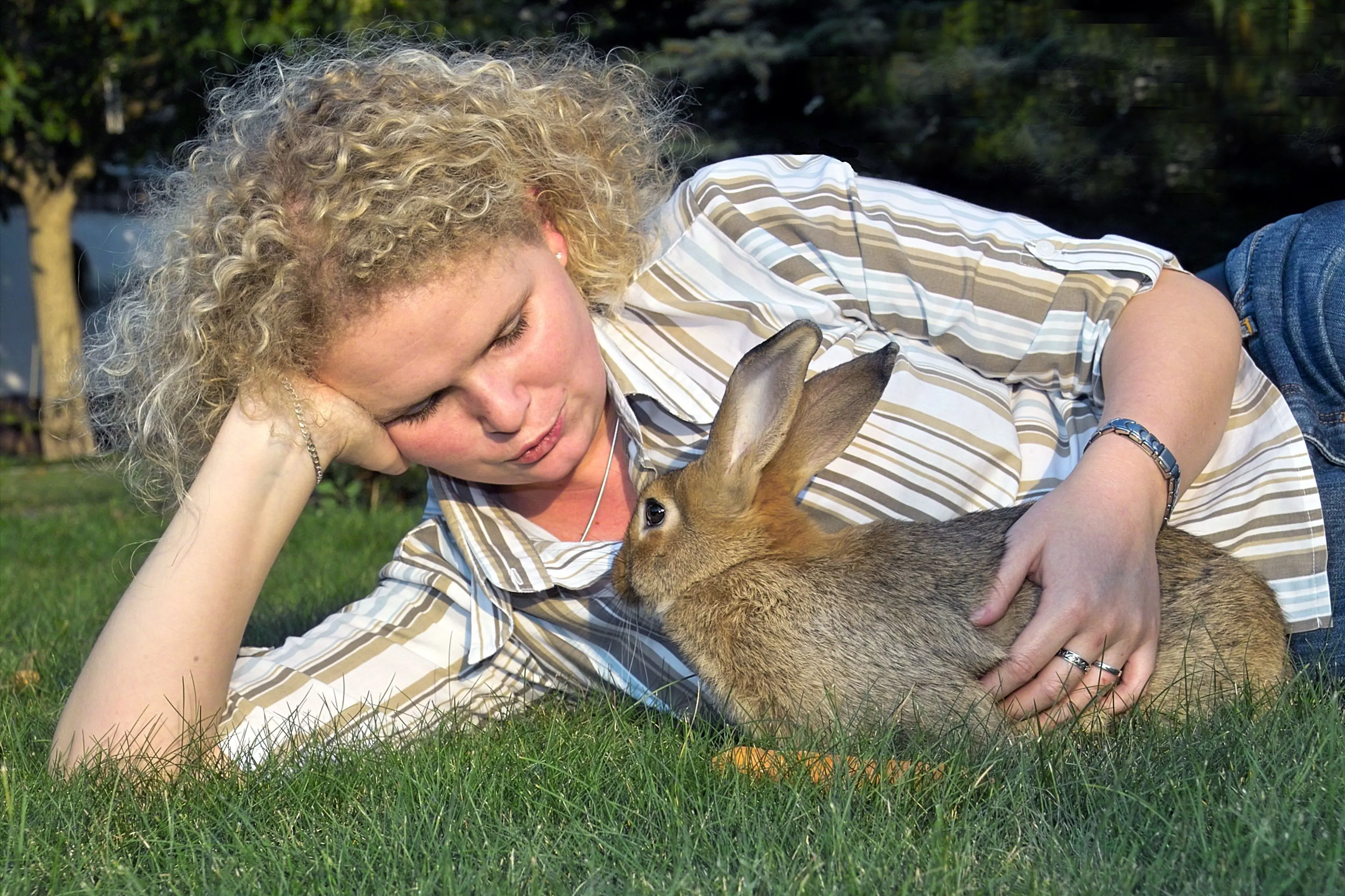Frau mit Kaninchen auf der Wiese
