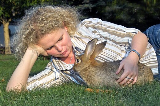 Frau mit Kaninchen auf der Wiese